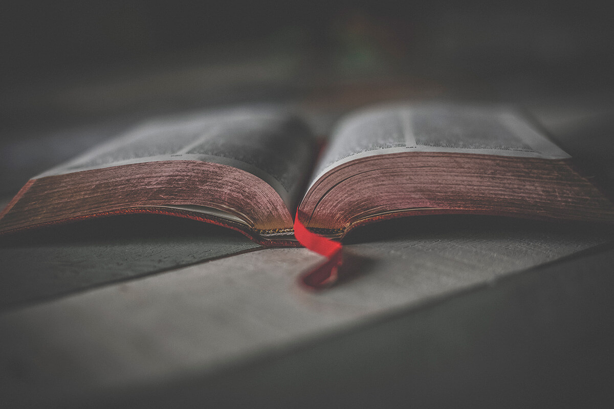 Desaturated Photo of Open Bible with Red Bookmark