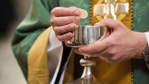 Priest Holding Eucharist